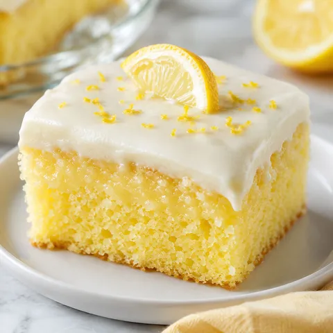 Lemonade cake slice with cream cheese frosting and lemon zest