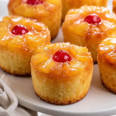 Pineapple upside-down cupcakes with cherries and glossy caramel topping