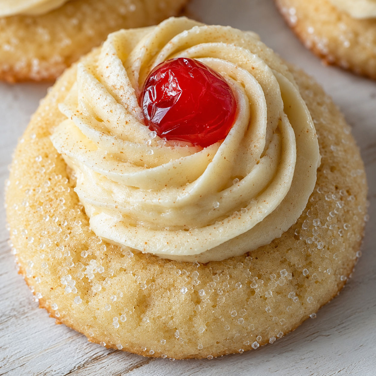 Eggnog cookie with velvet frosting rosette and red candied cherry
