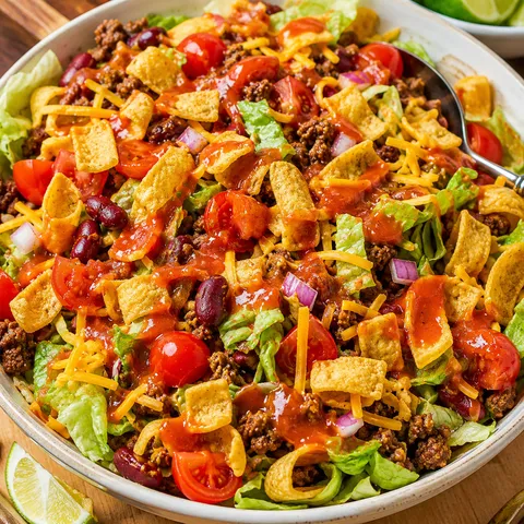 Frito taco salad with Catalina dressing, beef, cheddar, tomatoes, and corn chips