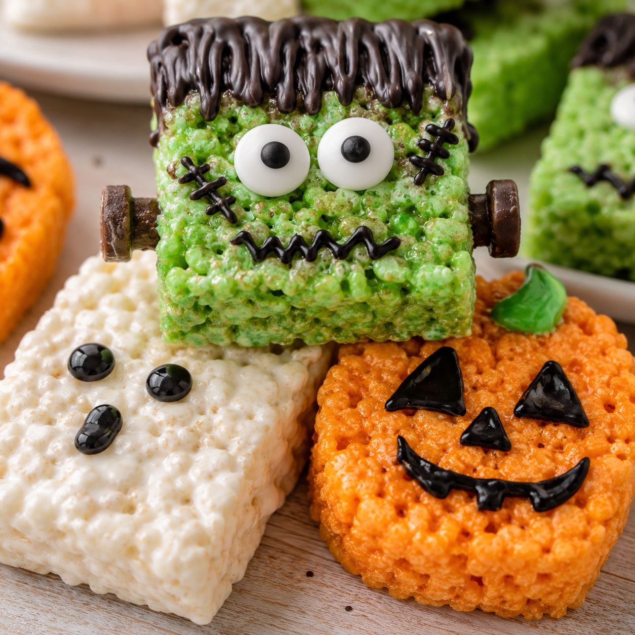 Stack of decorated Halloween Rice Krispie Treats as Frankenstein, ghost, and pumpkin monsters