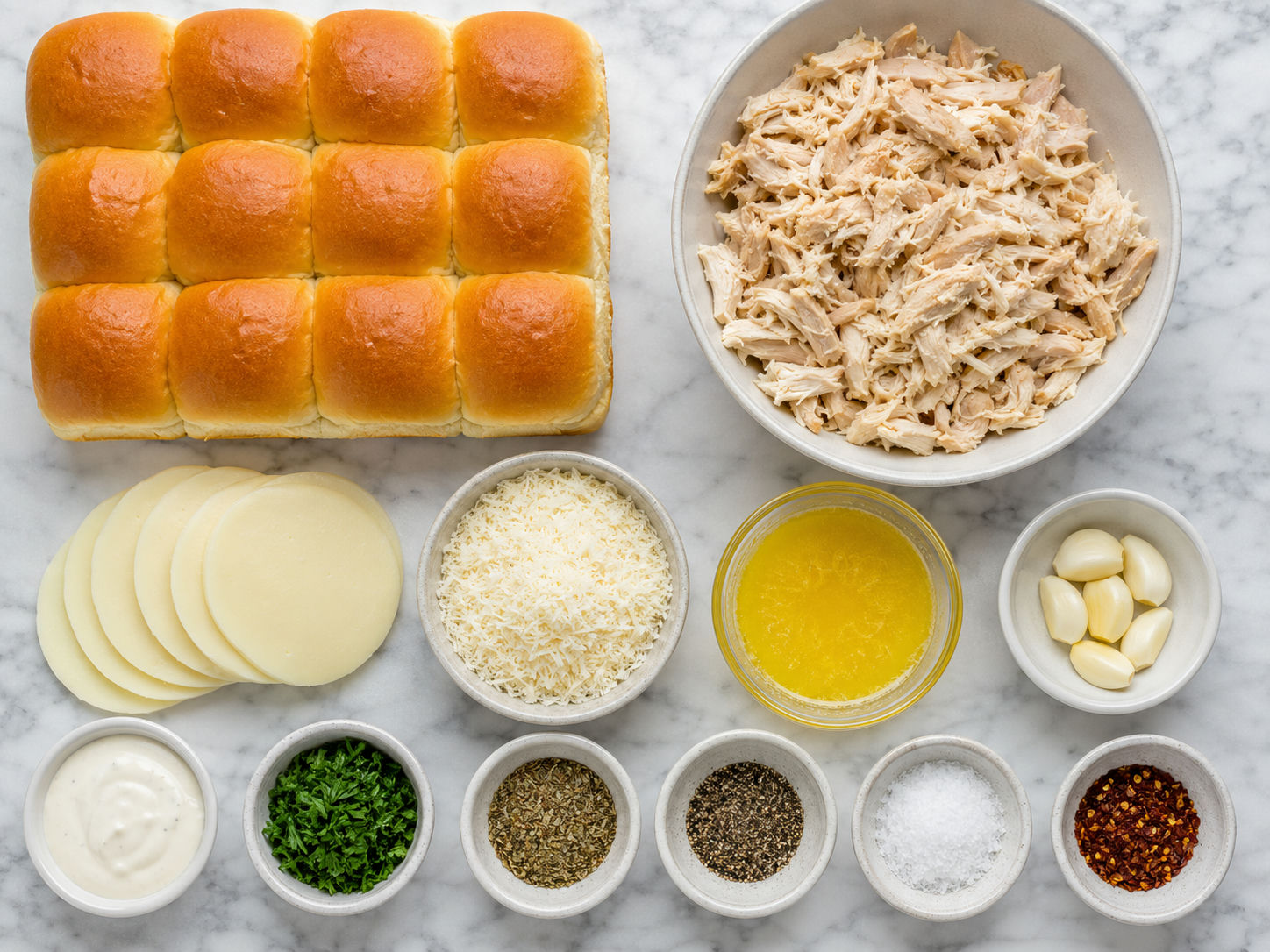 Ingredients for garlic parmesan chicken sliders with rolls, chicken, cheese, and butter