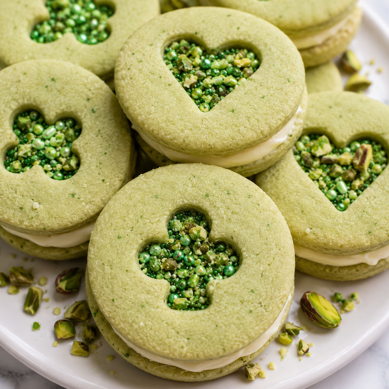 Green pistachio pudding Linzer cookies with buttercream and sprinkles
