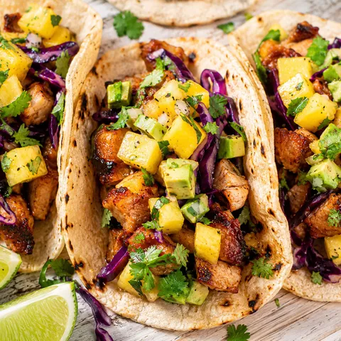 Huli huli chicken tacos with pineapple mango avocado salsa and cabbage
