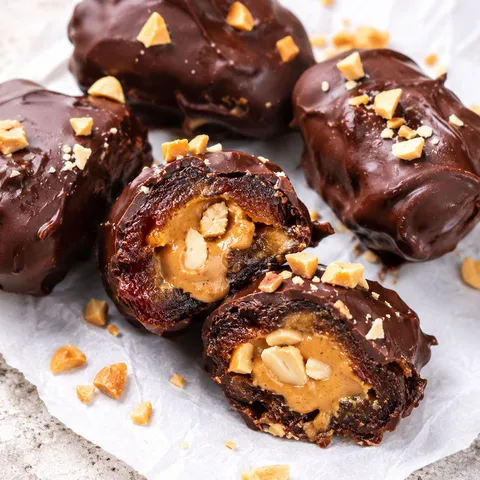 Chocolate date snickers filled with peanut butter and roasted peanuts