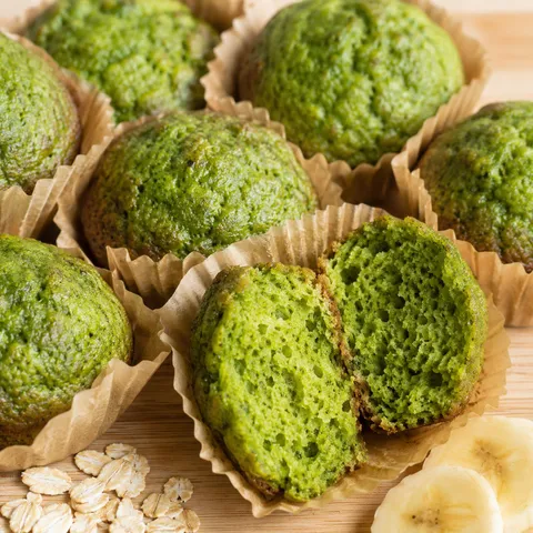 Green spinach mini muffins with a soft split crumb and banana slices