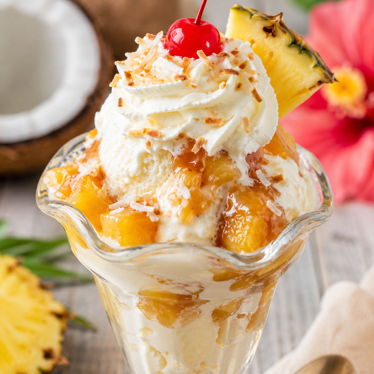 Piña colada ice cream sundae with pineapple, coconut, whipped cream, and cherry