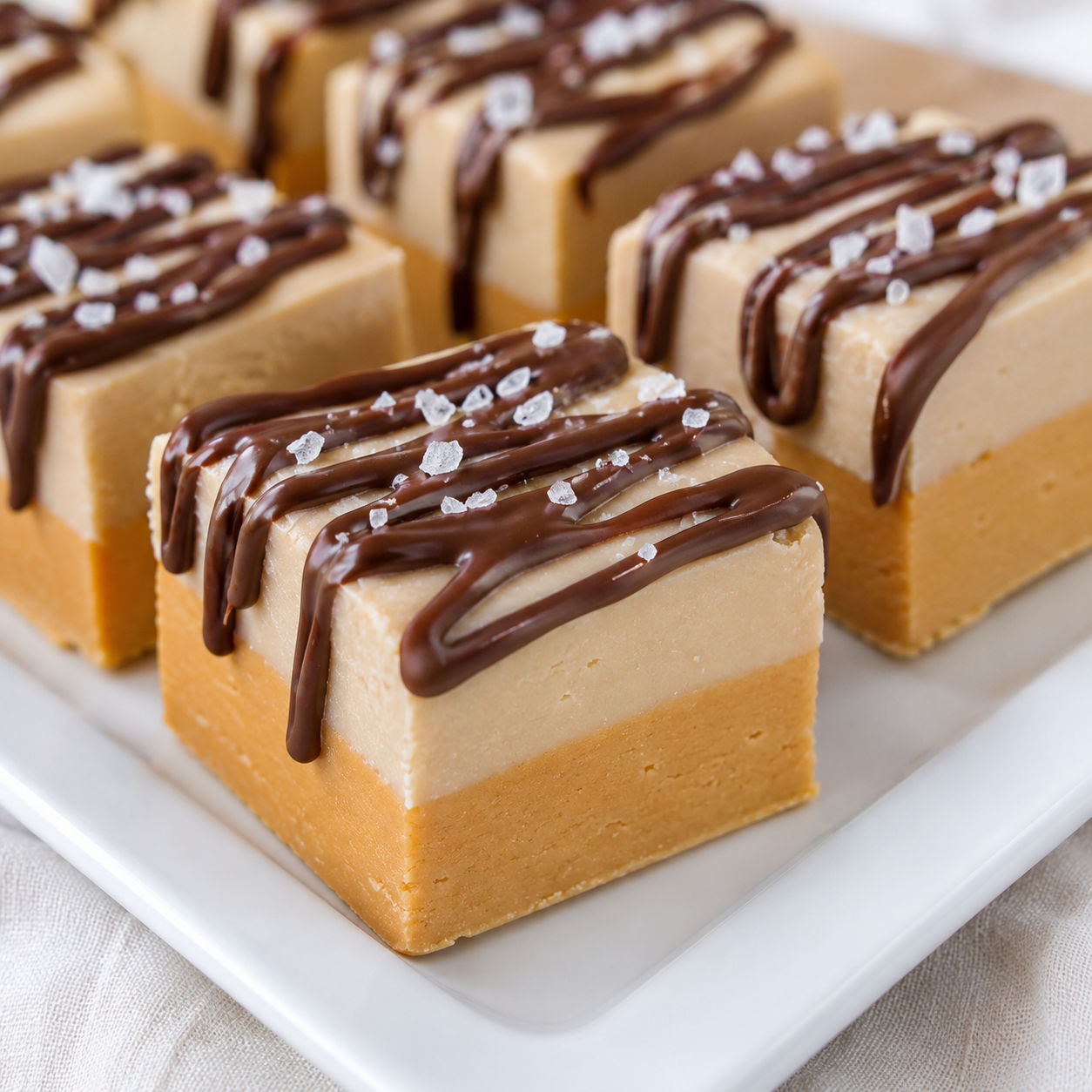 Layered caramel coffee fudge squares with dark chocolate drizzle