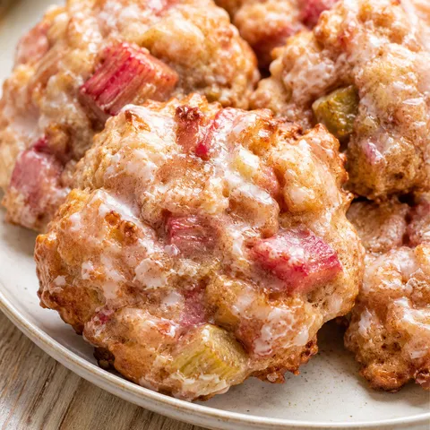 Baked rhubarb cinnamon fritters with vanilla glaze on a ceramic plate
