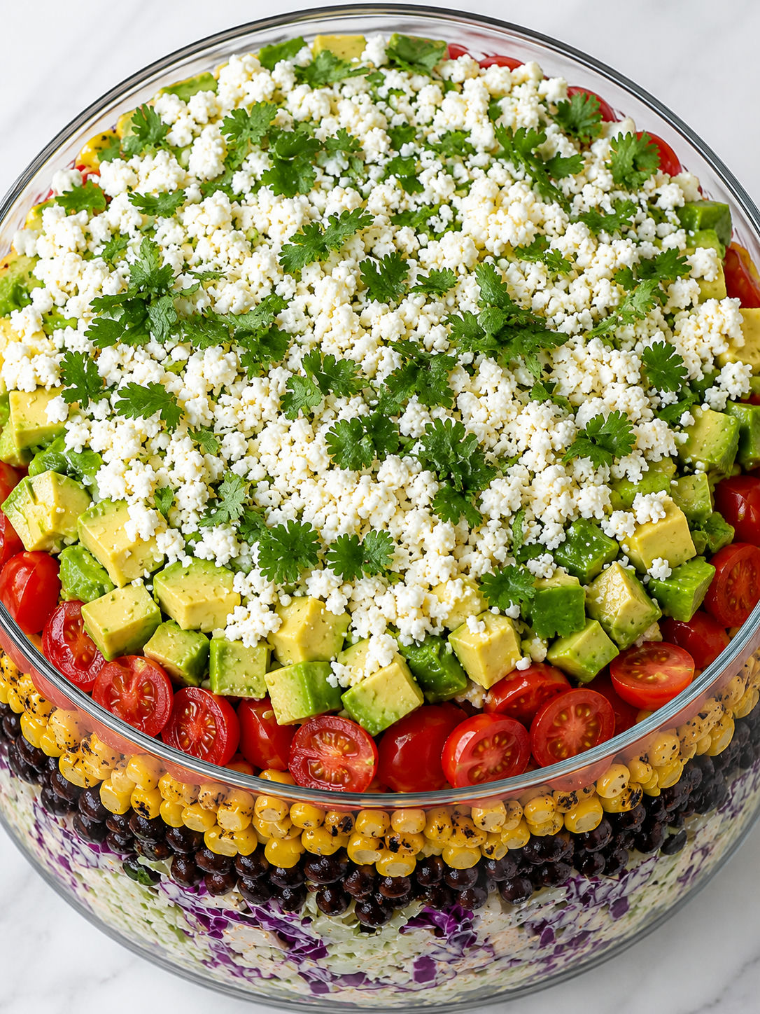 Top-down layered Mexican coleslaw tomato corn salad with cotija cheese and cilantro