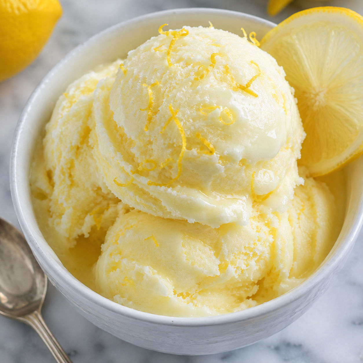 Limoncello lemon gelato scoops with lemon zest in a white bowl