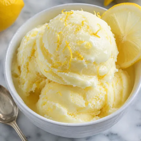 Limoncello lemon gelato scoops with lemon zest in a white bowl