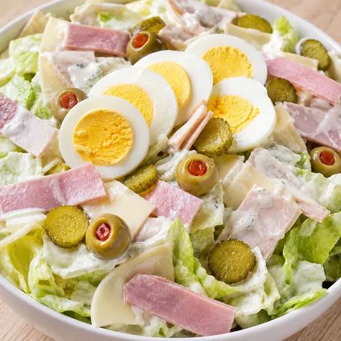 Maurice salad with ham, turkey, Swiss, pickles, olives, and creamy dressing