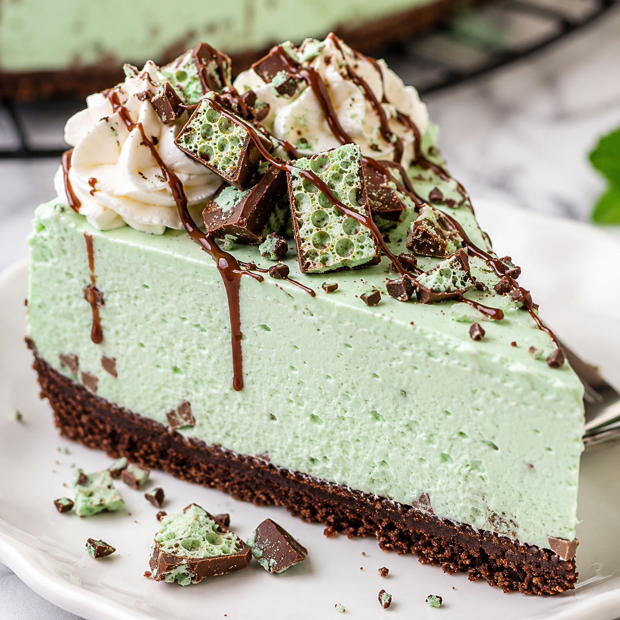 Mint Aero Cheesecake slice with whipped cream and chocolate drizzle