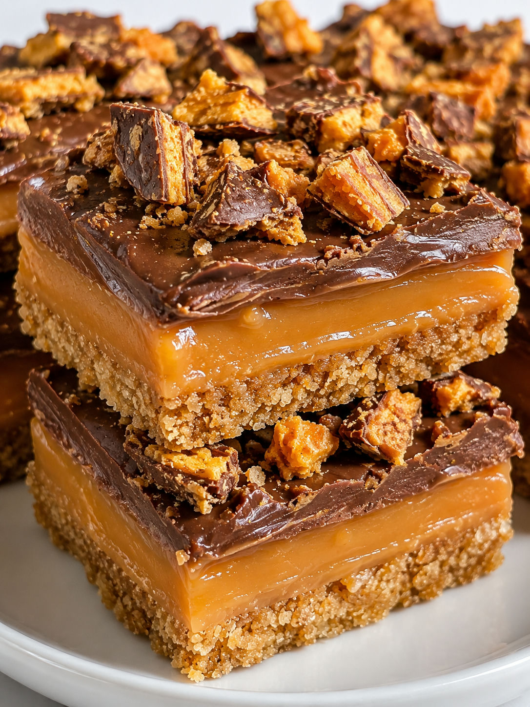 Stacked Butterfinger caramel bars with glossy chocolate and candy topping