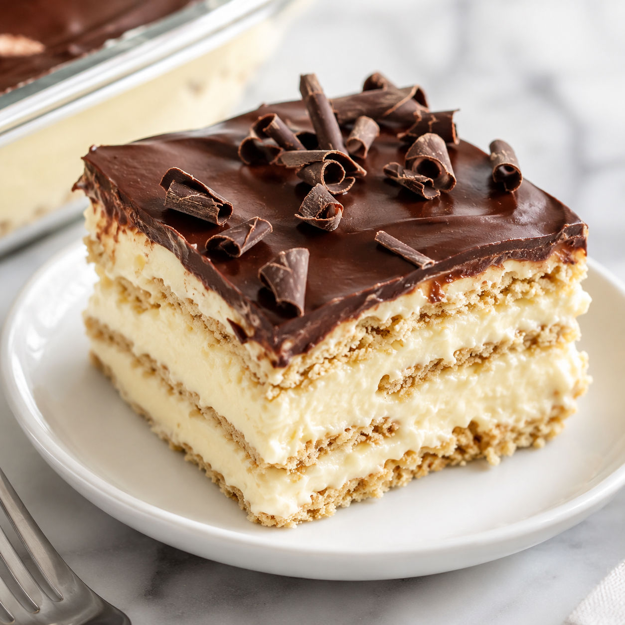 No-bake chocolate eclair dessert slice with vanilla layers and glossy glaze