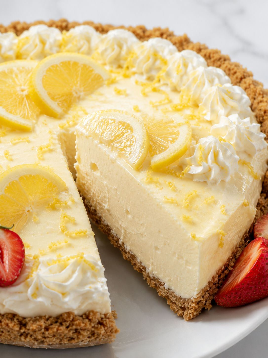 Creamy no-bake lemonade pie slice with lemon zest and whipped cream