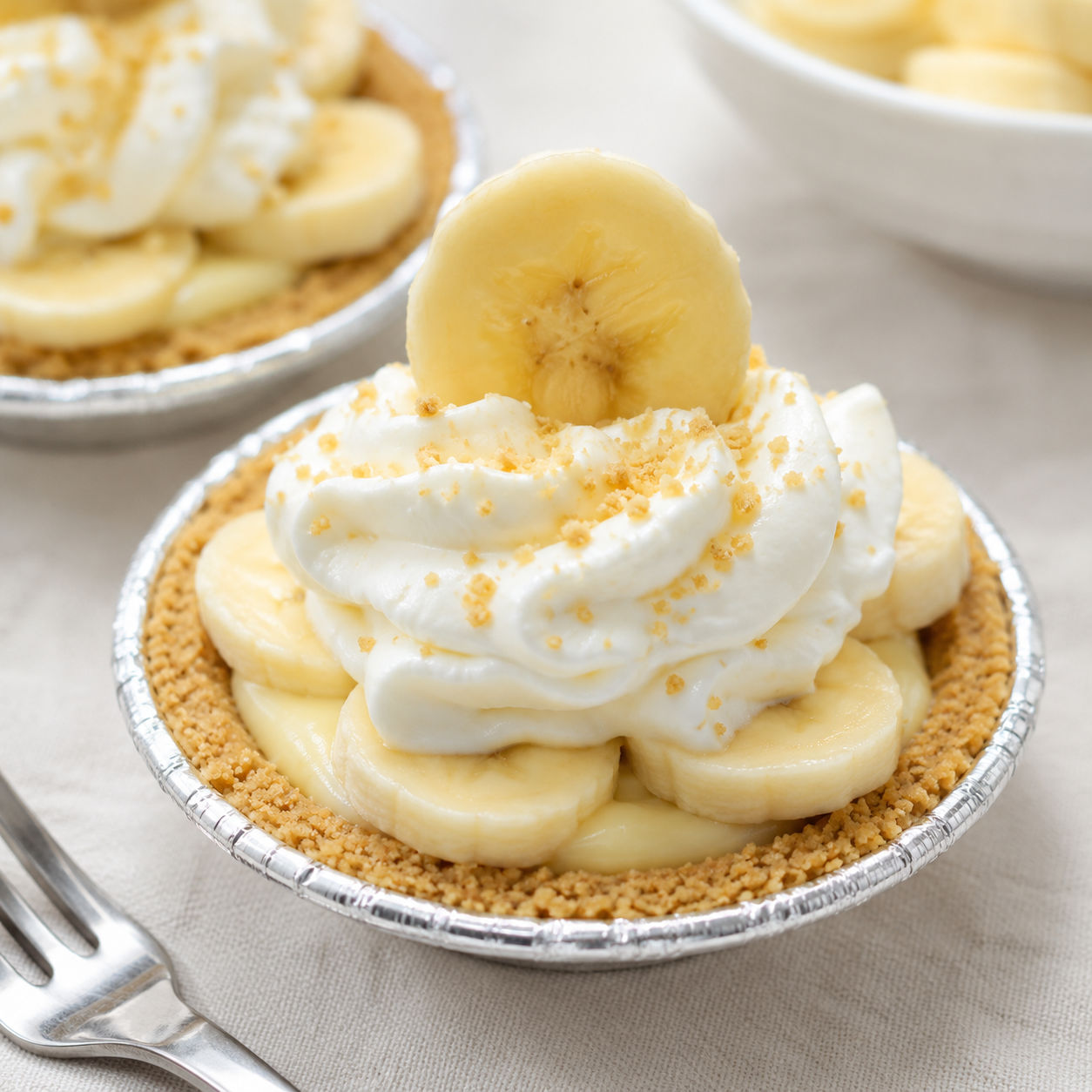 Mini banana cream pies with whipped cream and banana slices