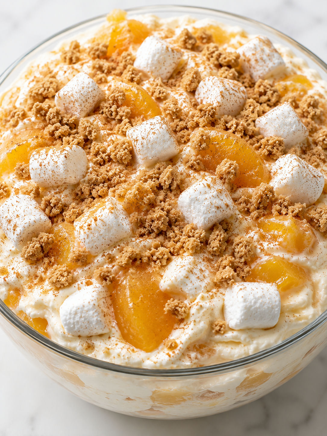 Creamy peach cobbler cheesecake salad topped with cinnamon graham crumbs