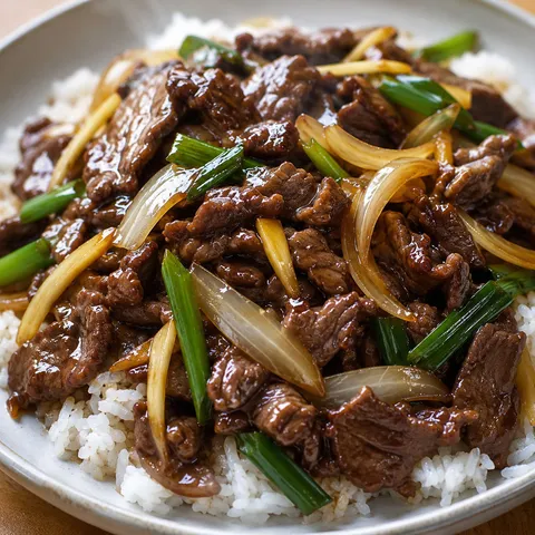 Oyster sauce beef stir-fry with onions, ginger, and green onions over rice