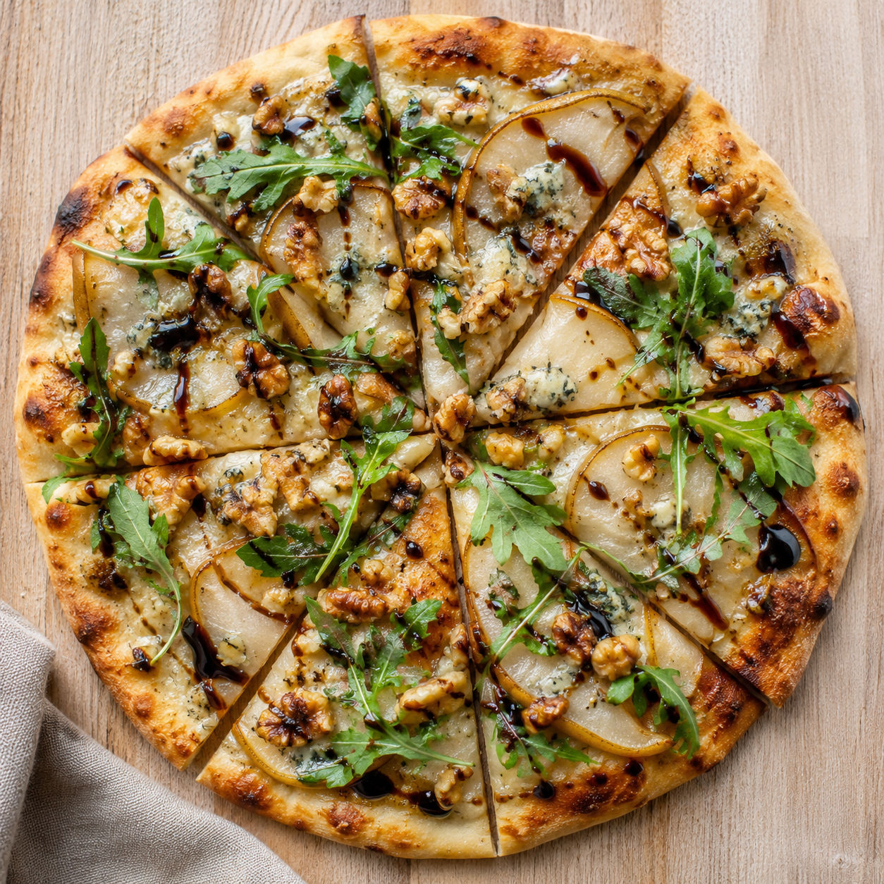 Pear Gorgonzola flatbread with walnut crumble, arugula, and balsamic glaze