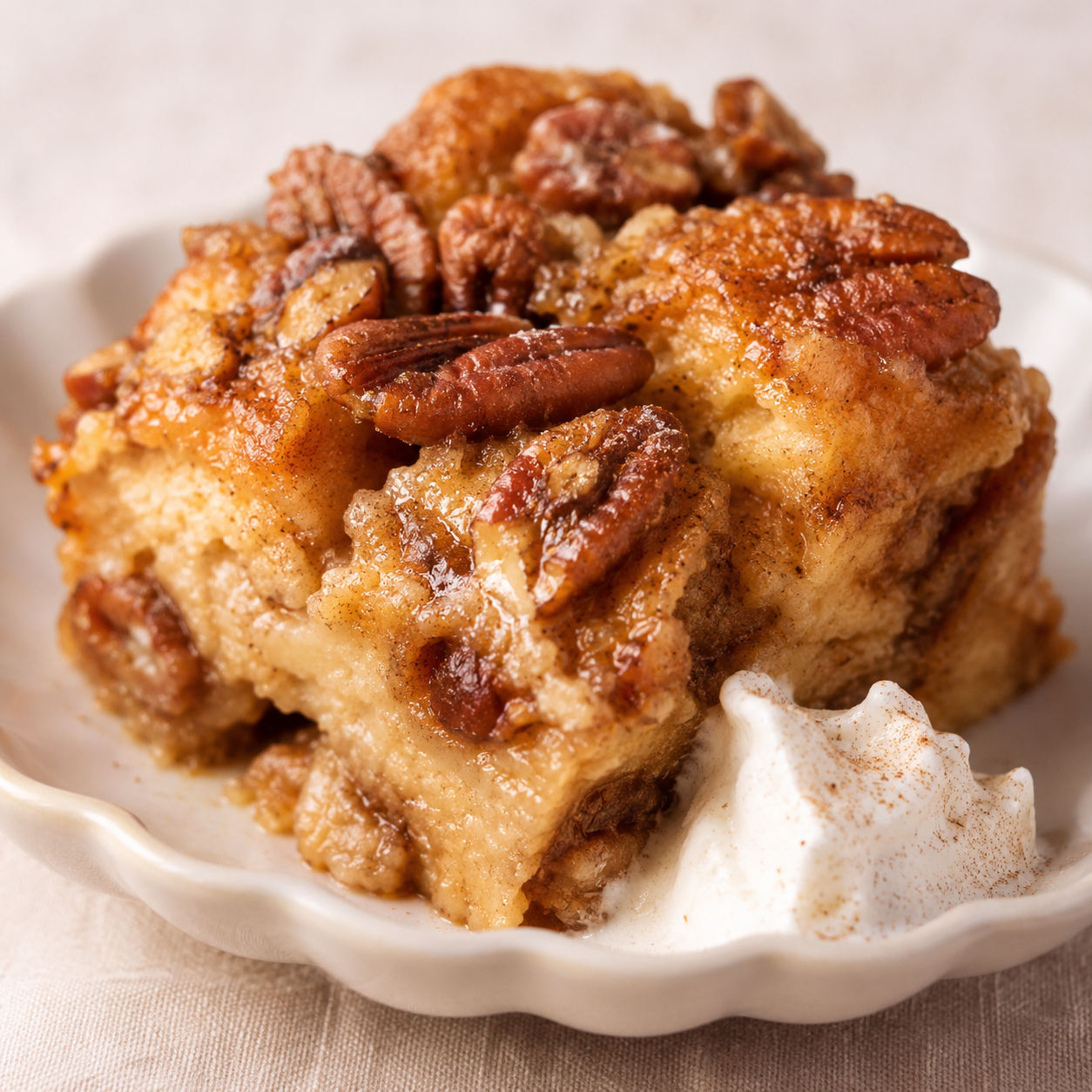Pecan pie bread pudding with glossy pecans and whipped cream