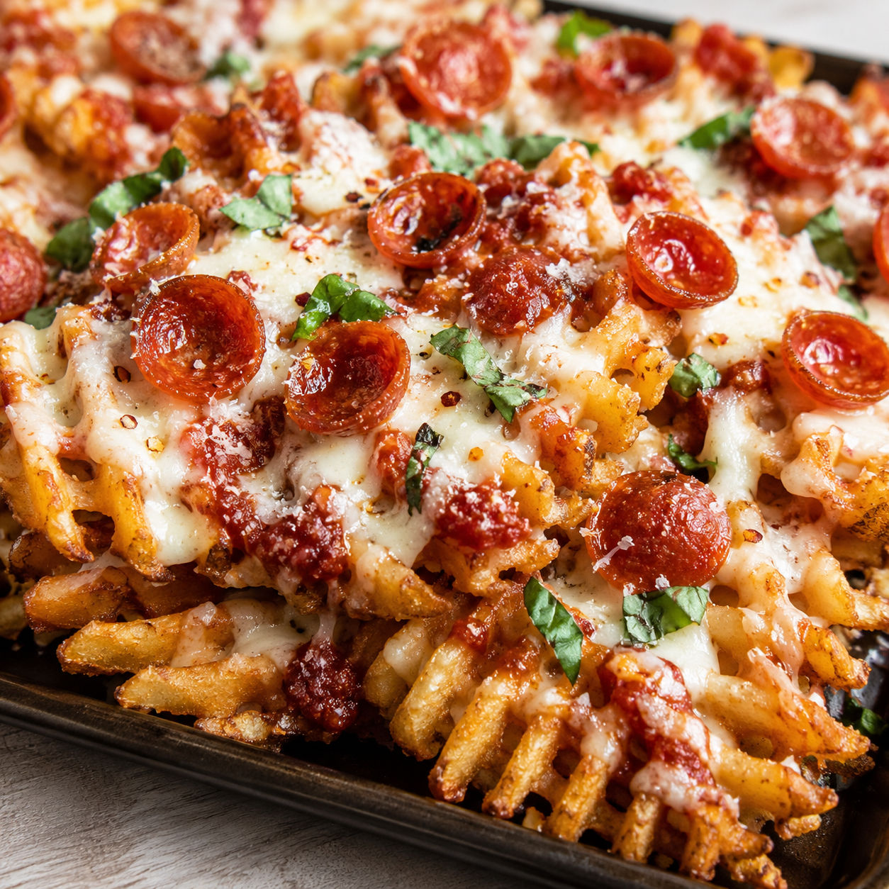 Pizza Fries with melted cheese, pepperoni, basil, and marinara