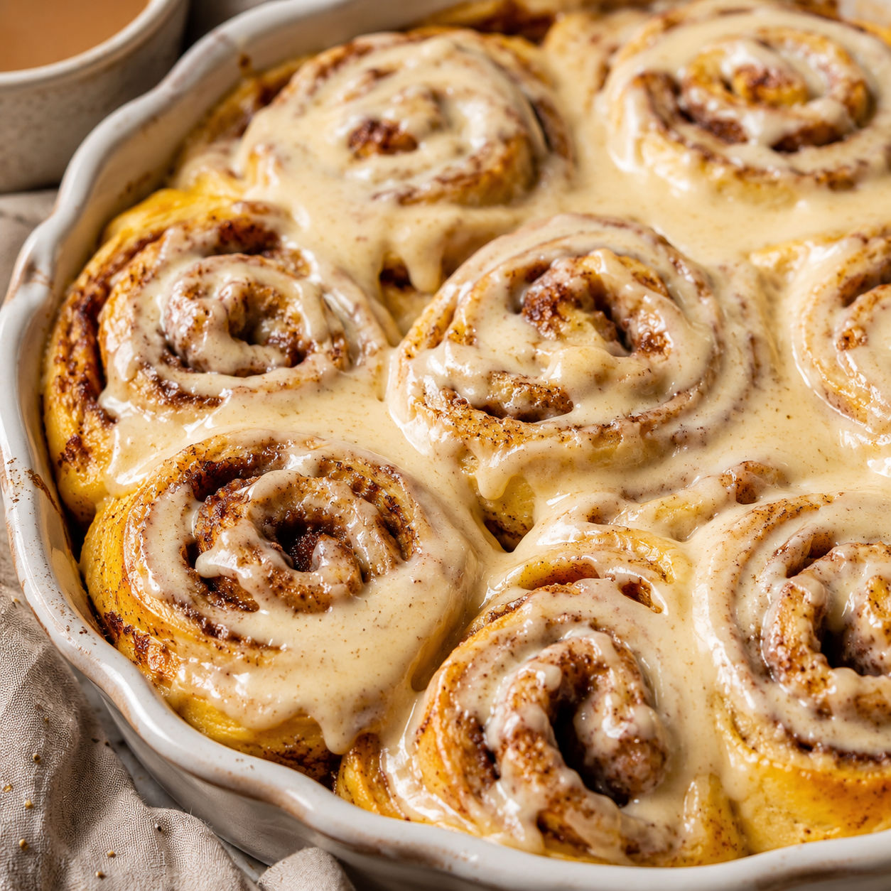 Pumpkin cinnamon rolls with maple cream cheese frosting in a pan