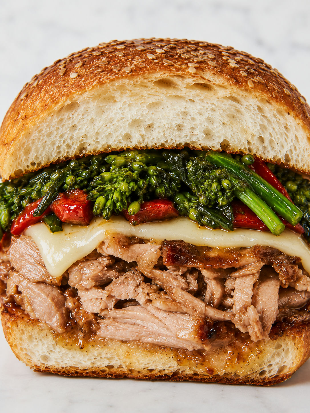 Roast pork sandwich packed with provolone, broccoli rabe, and peppers