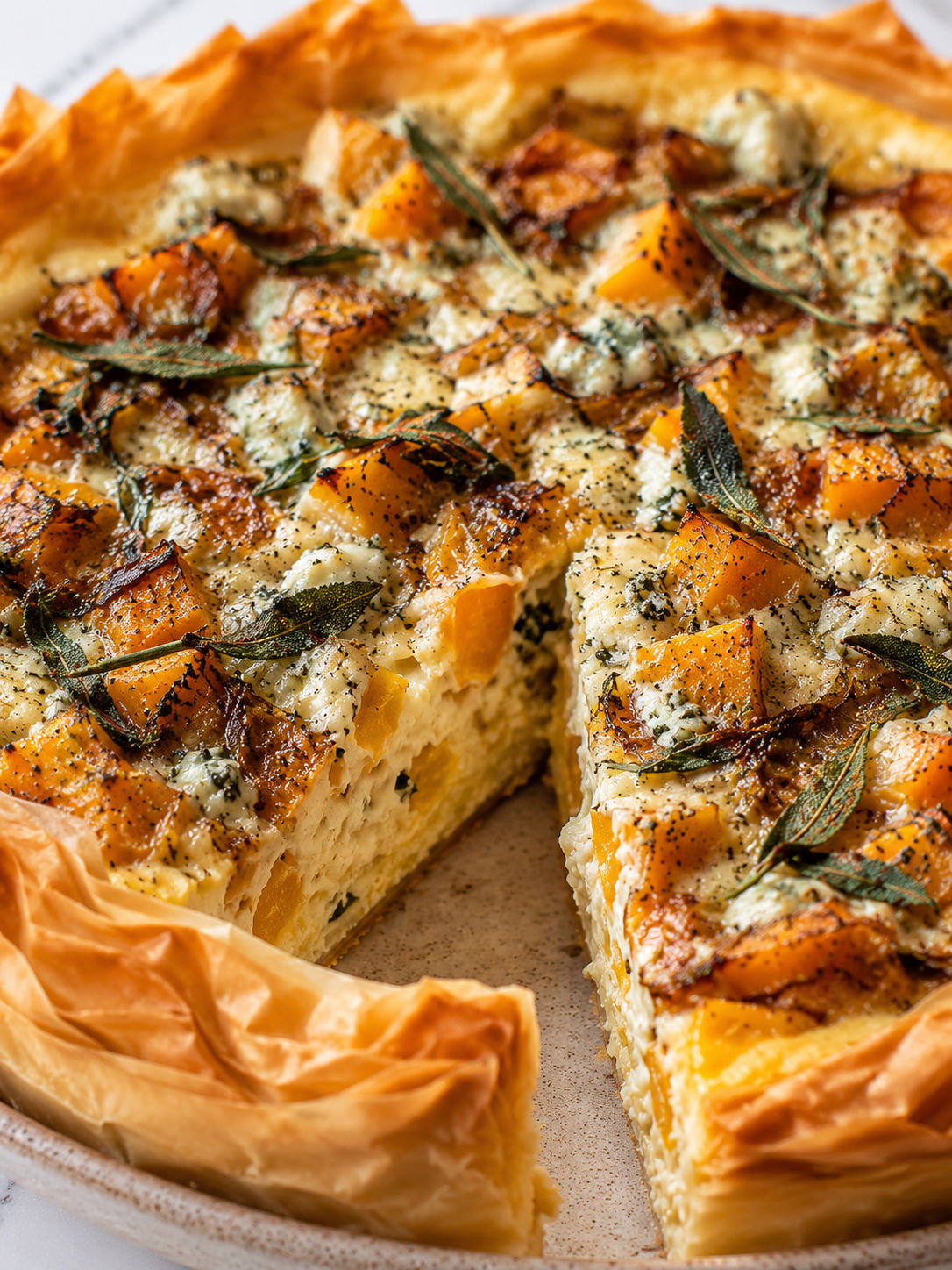 Roasted Pumpkin Quiche with Caramelized Onions, Gorgonzola, and Sage, plated and served