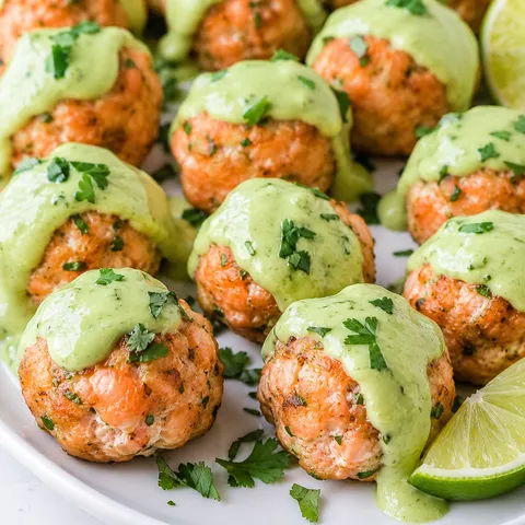 Salmon meatballs topped with creamy avocado sauce and cilantro