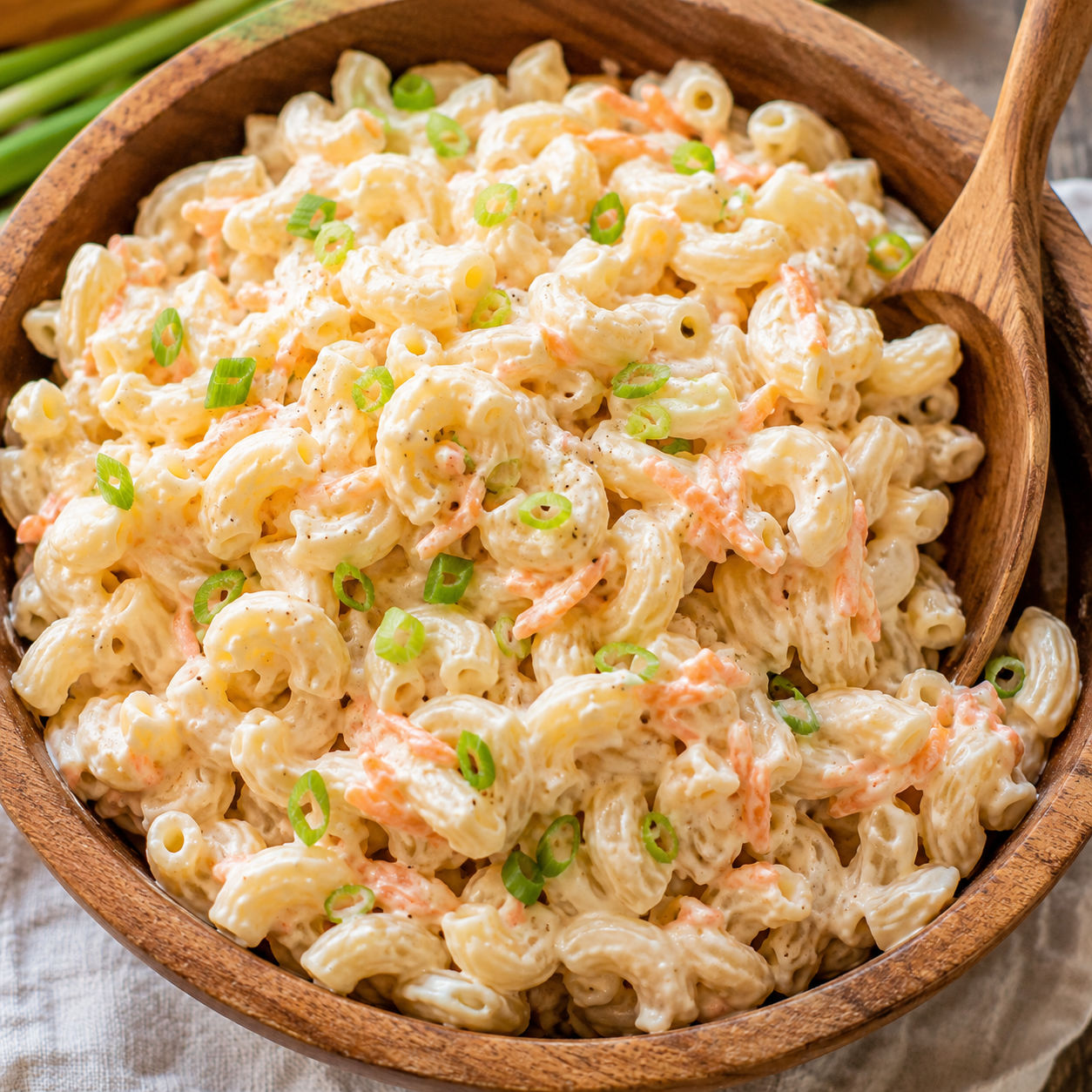 Creamy Hawaiian macaroni salad with carrot shreds in a wooden bowl