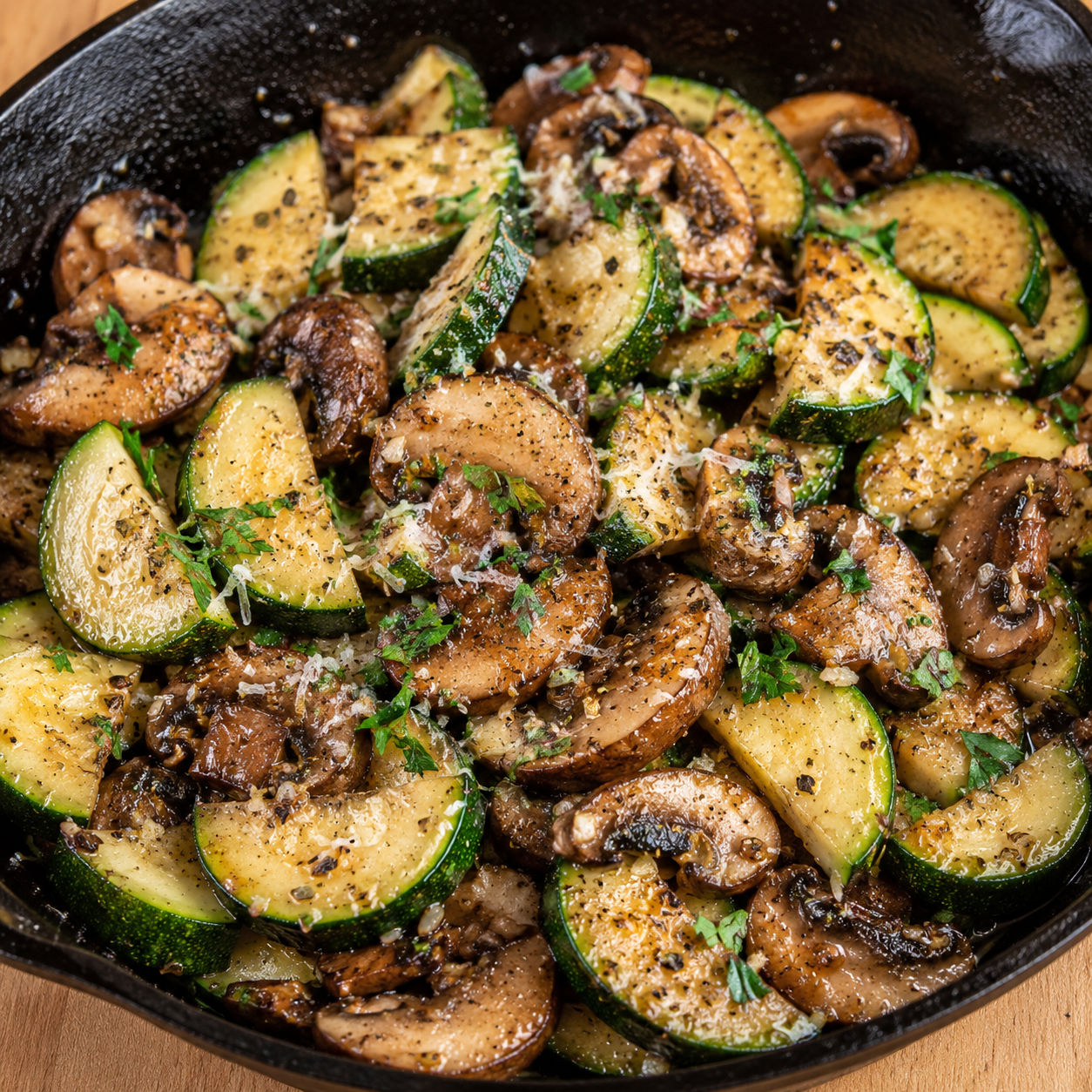 Skillet zucchini and mushrooms with garlic and parmesan in a cast-iron pan