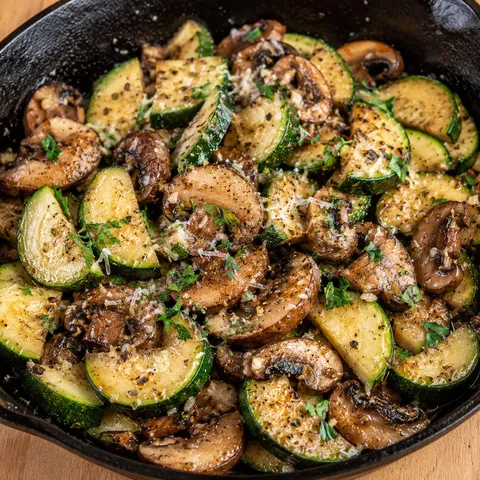 Skillet zucchini and mushrooms with garlic and parmesan in a cast-iron pan