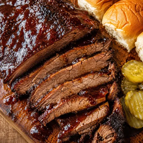 Sliced BBQ beef brisket with sticky sauce and caramelized edges