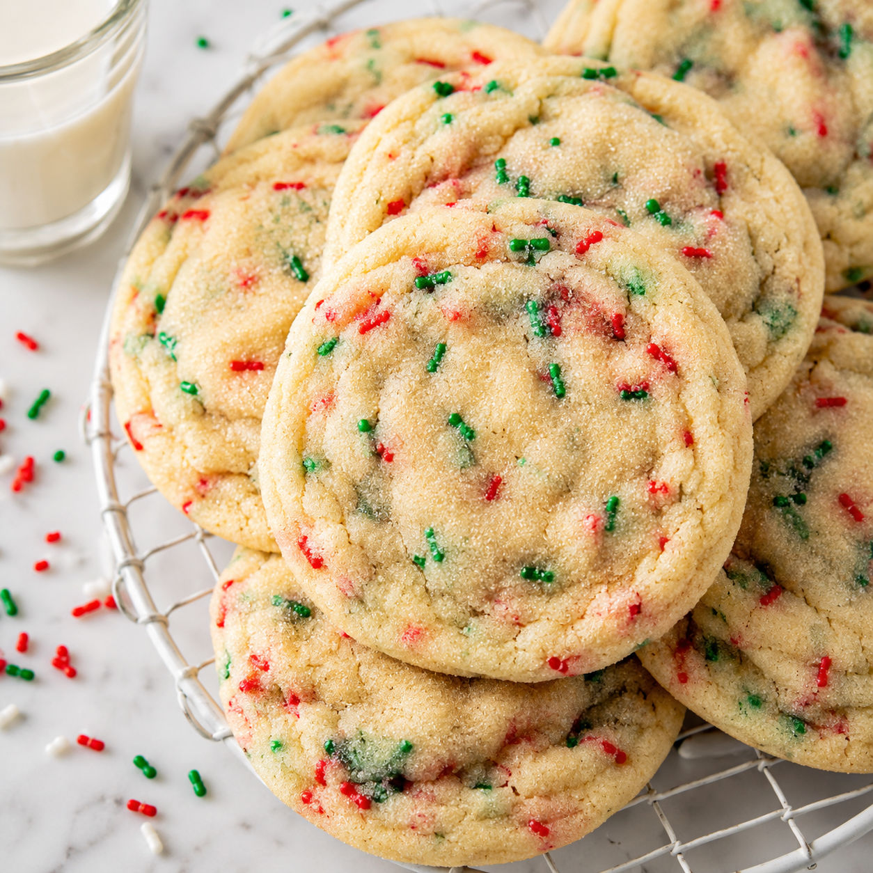 Soft Christmas sprinkle cookies with sugared tops on a cooling rack