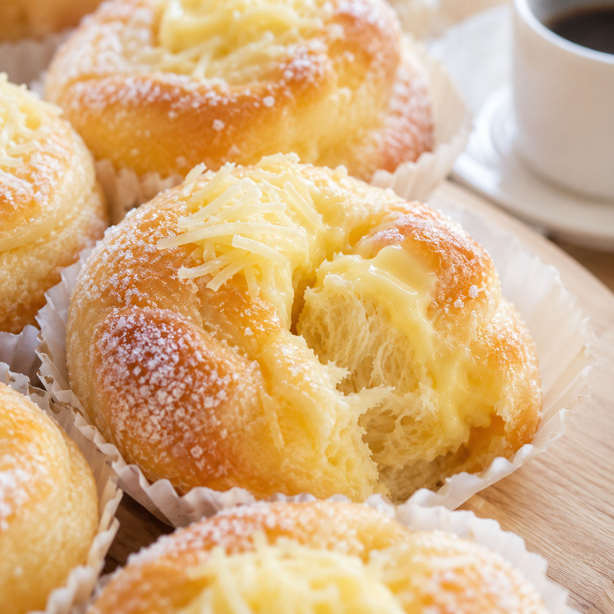 Soft ensaymada rolls with butter and sugar topping in paper molds