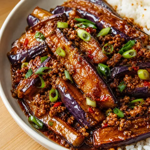 Spicy Sichuan eggplant with pork mince and scallions in a shallow bowl