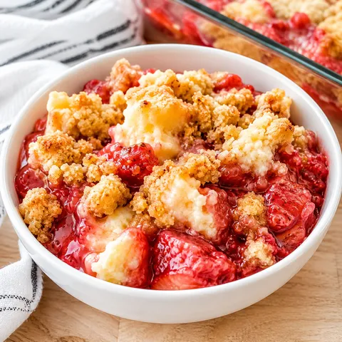 Strawberry cheesecake dump cake with golden topping in a white bowl
