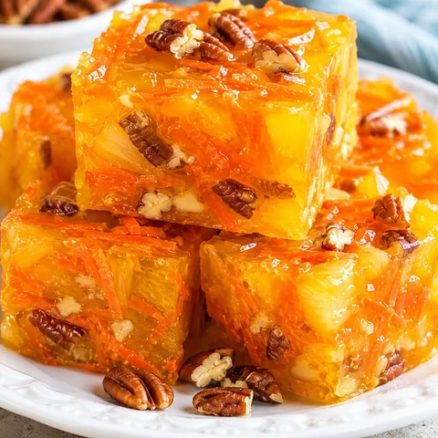 Sunshine Salad squares with pineapple, carrots, and pecans on a white plate