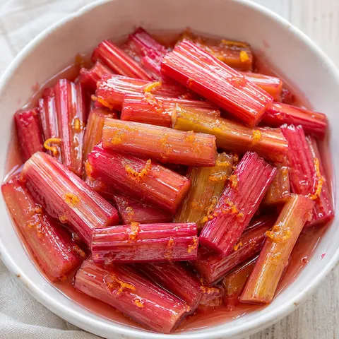 Sweet roasted rhubarb with orange zest in a white bowl