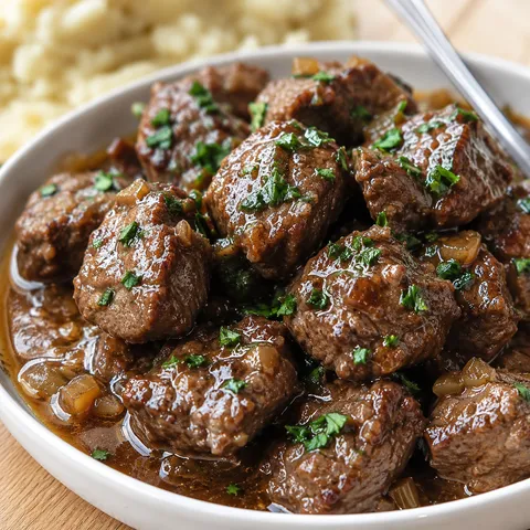 Tender Crock Pot steak bites in garlic butter broth with parsley