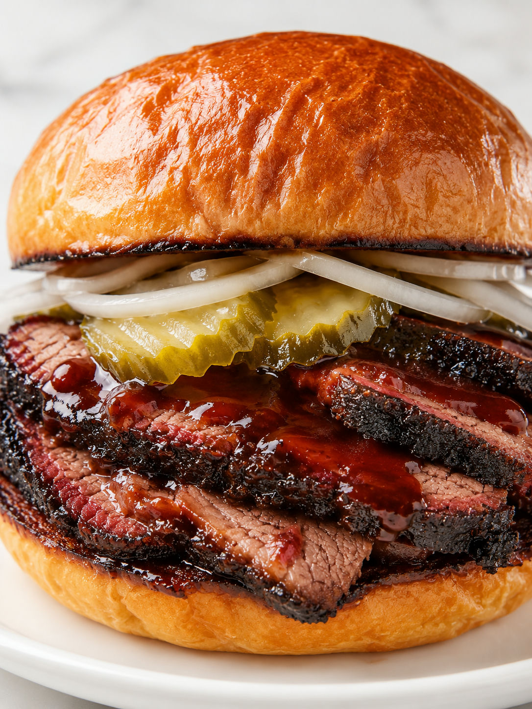 Tall Texas brisket sandwich stacked with pickles and onion