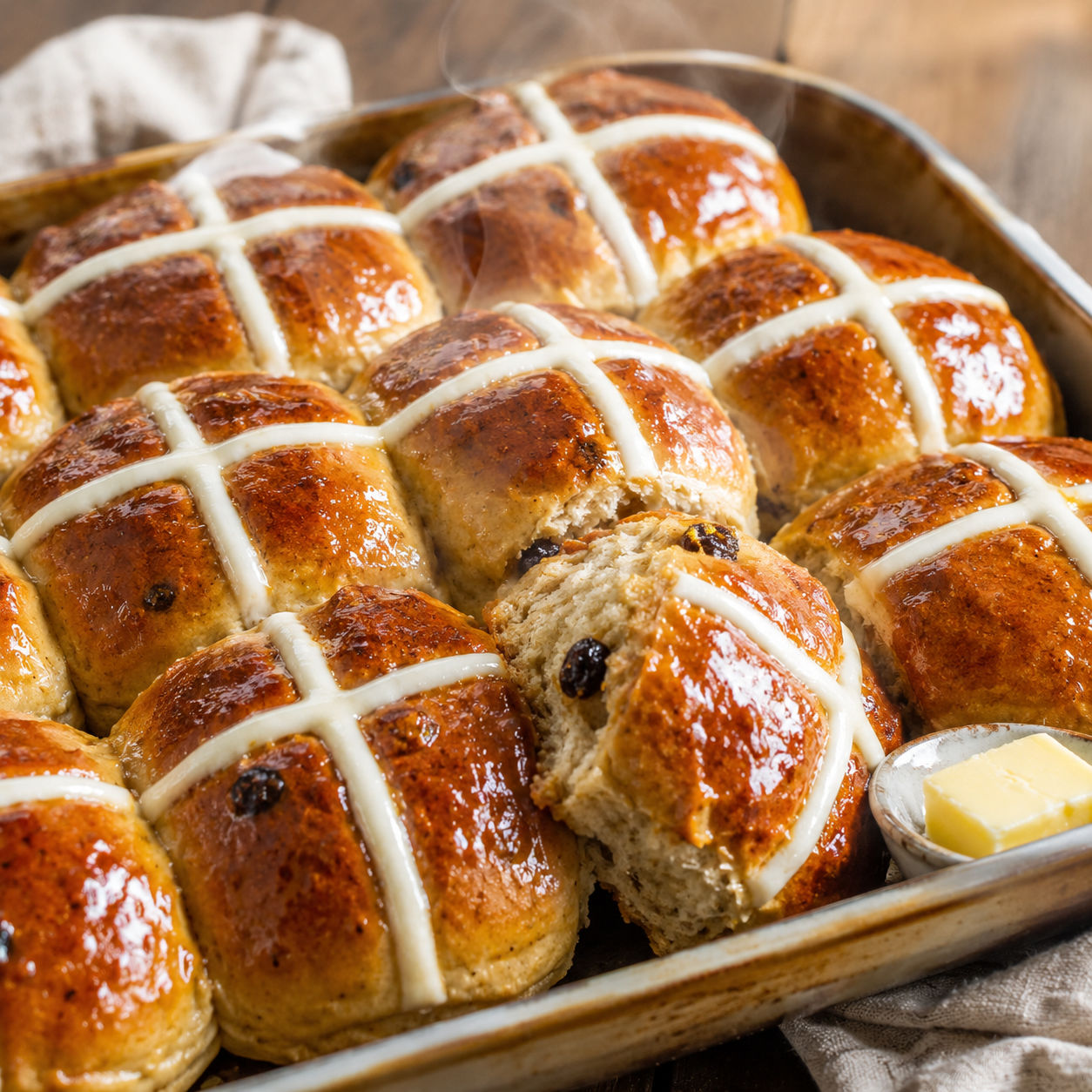 Glossy traditional hot cross buns with white crosses and sultanas