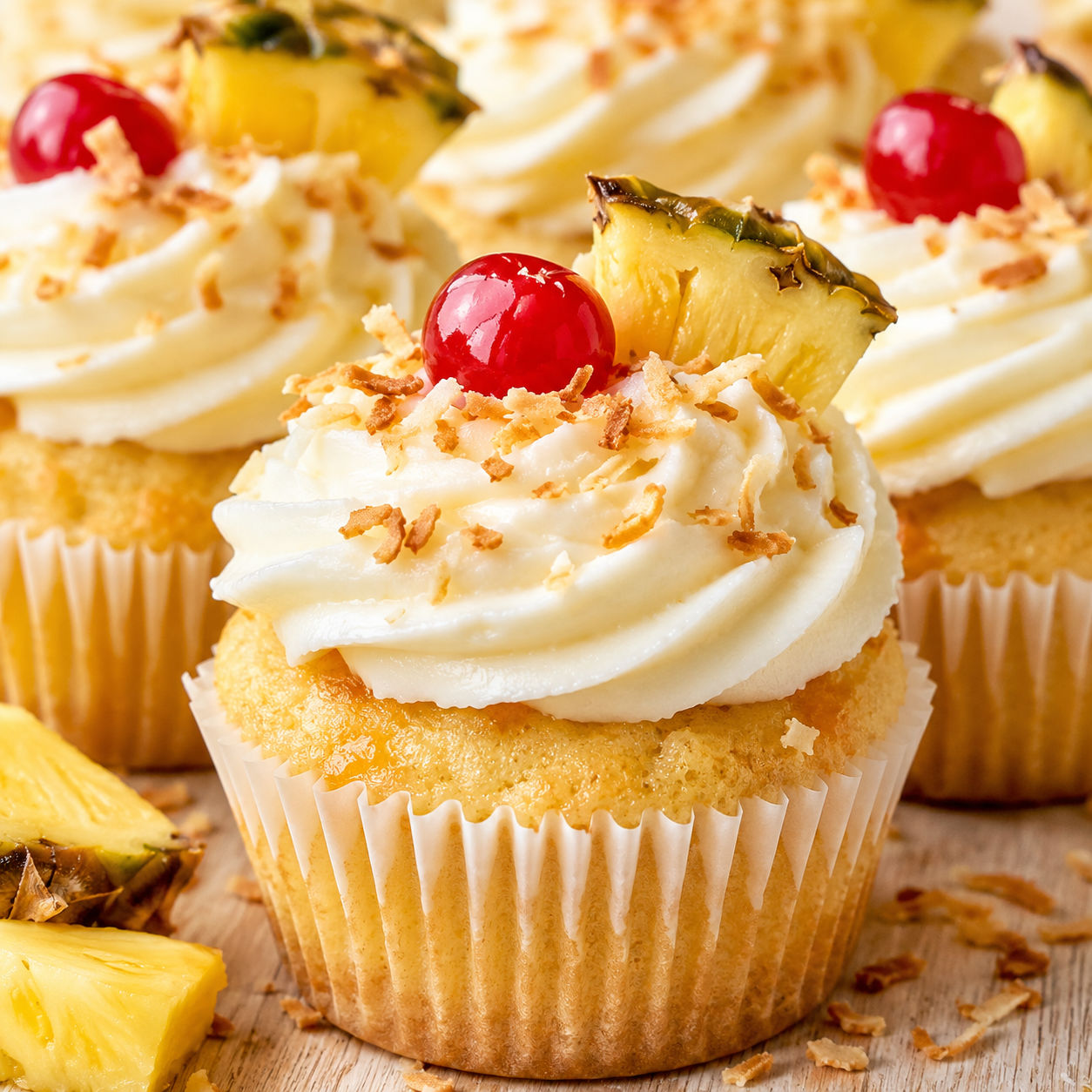 Tropical piña colada cupcakes with coconut frosting and cherries
