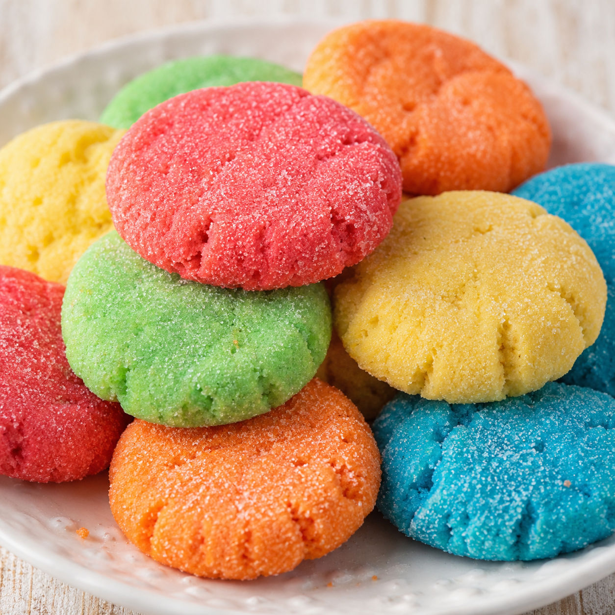 Colorful Jello sugar cookies stacked on a white plate