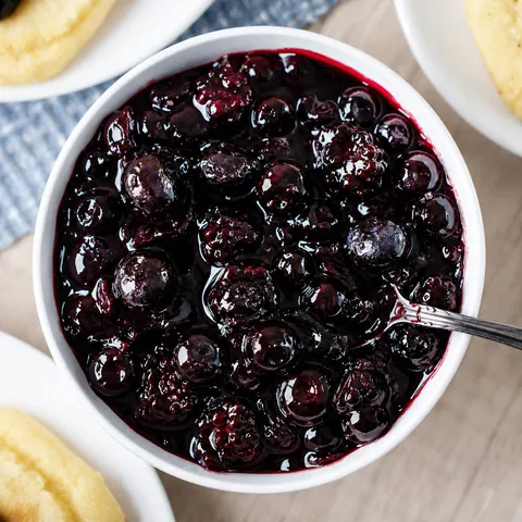 Wojapi berry sauce in a white bowl with fry bread nearby