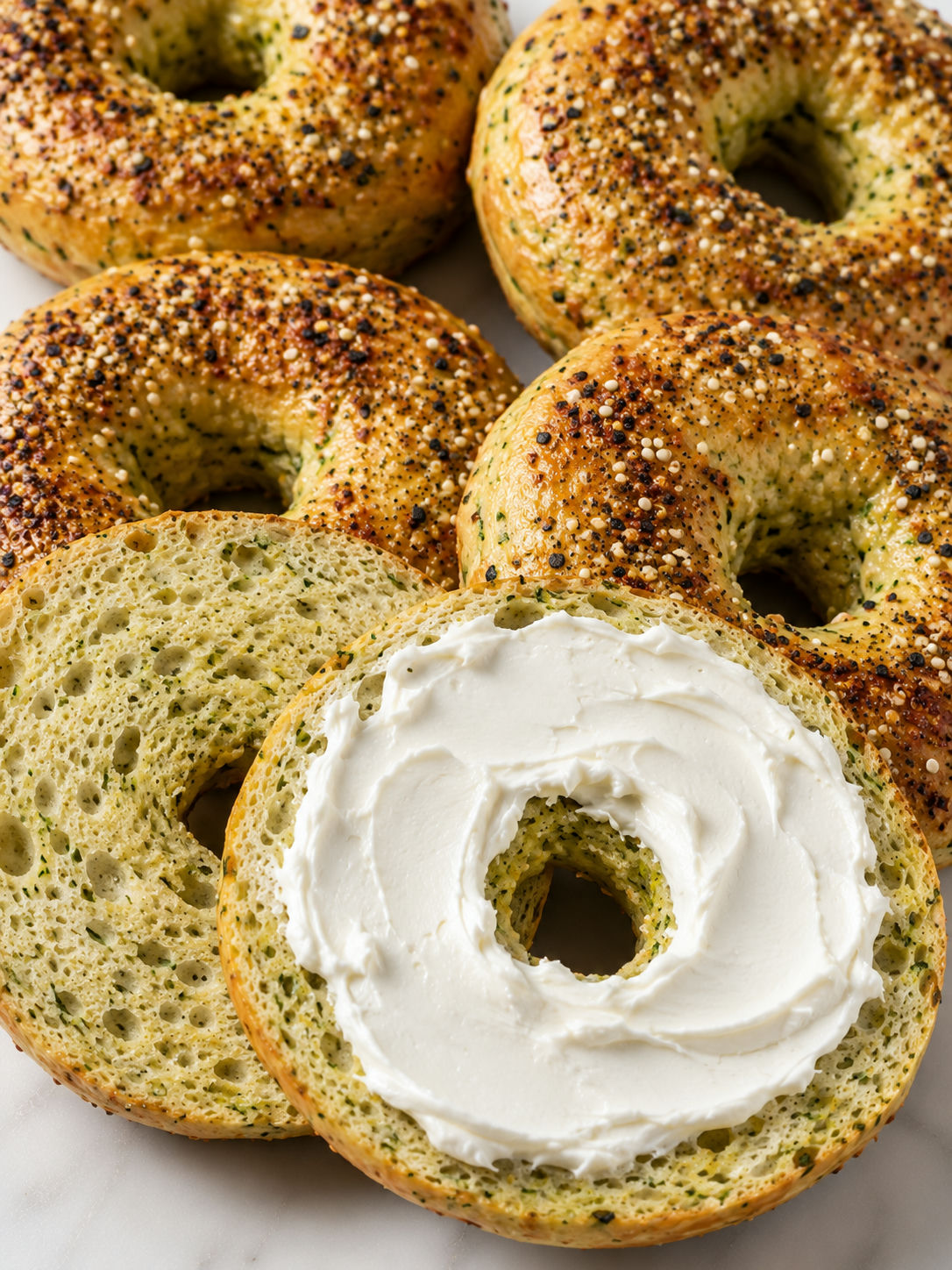Keto zucchini bagels with golden tops, everything seasoning, and cream cheese