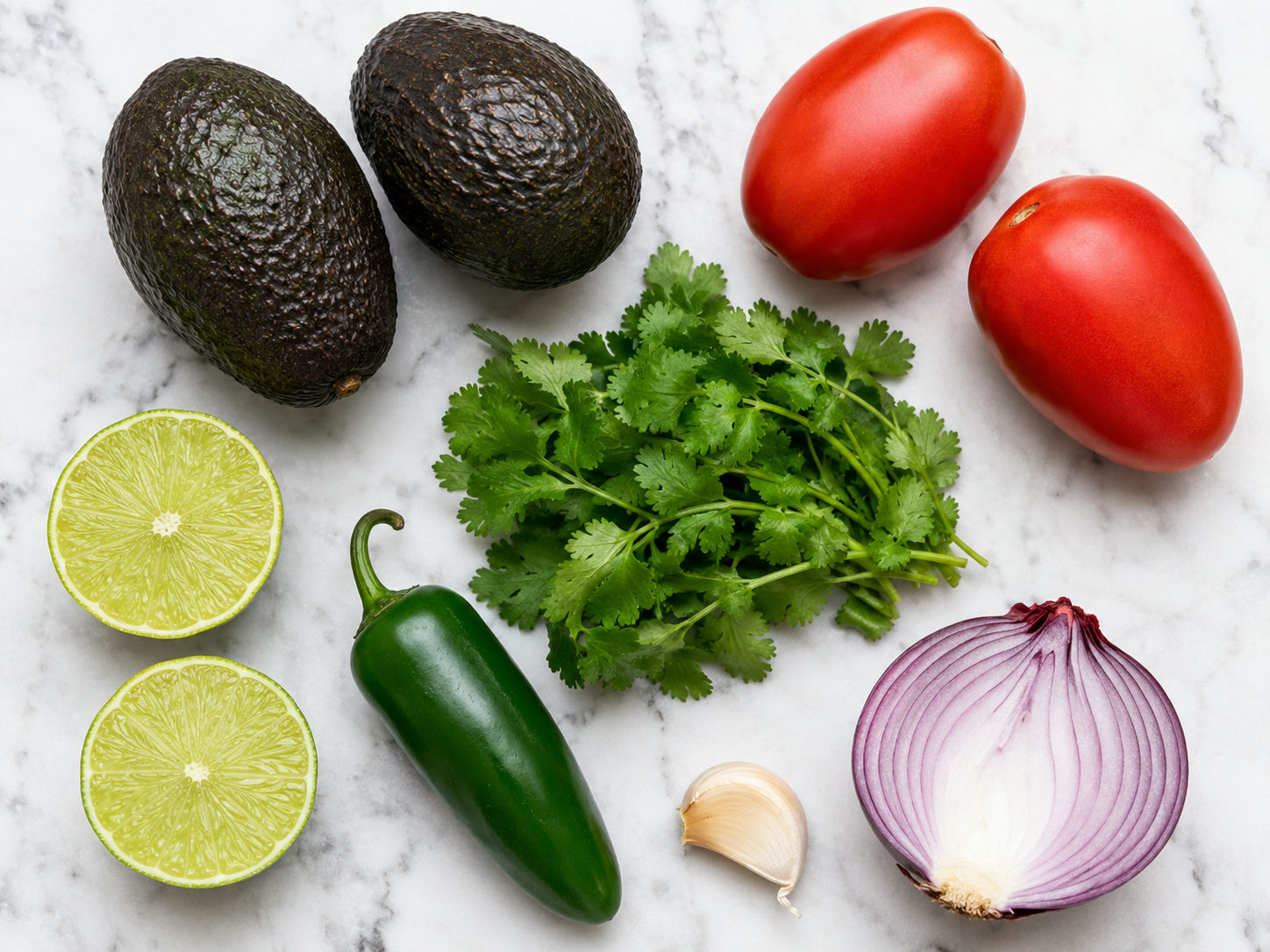 Raw ingredients for cilantro lime avocado salsa arranged on a marble surface