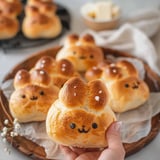 A person is holding a bun with a face drawn on it.